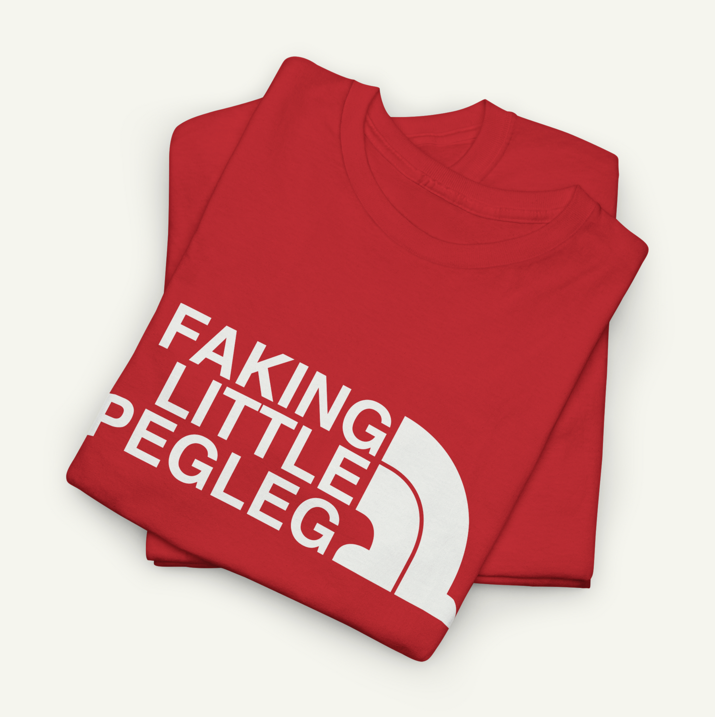 A red t-shirt with white text that says "FAKING LITTLE PEGLEG" printed on it.