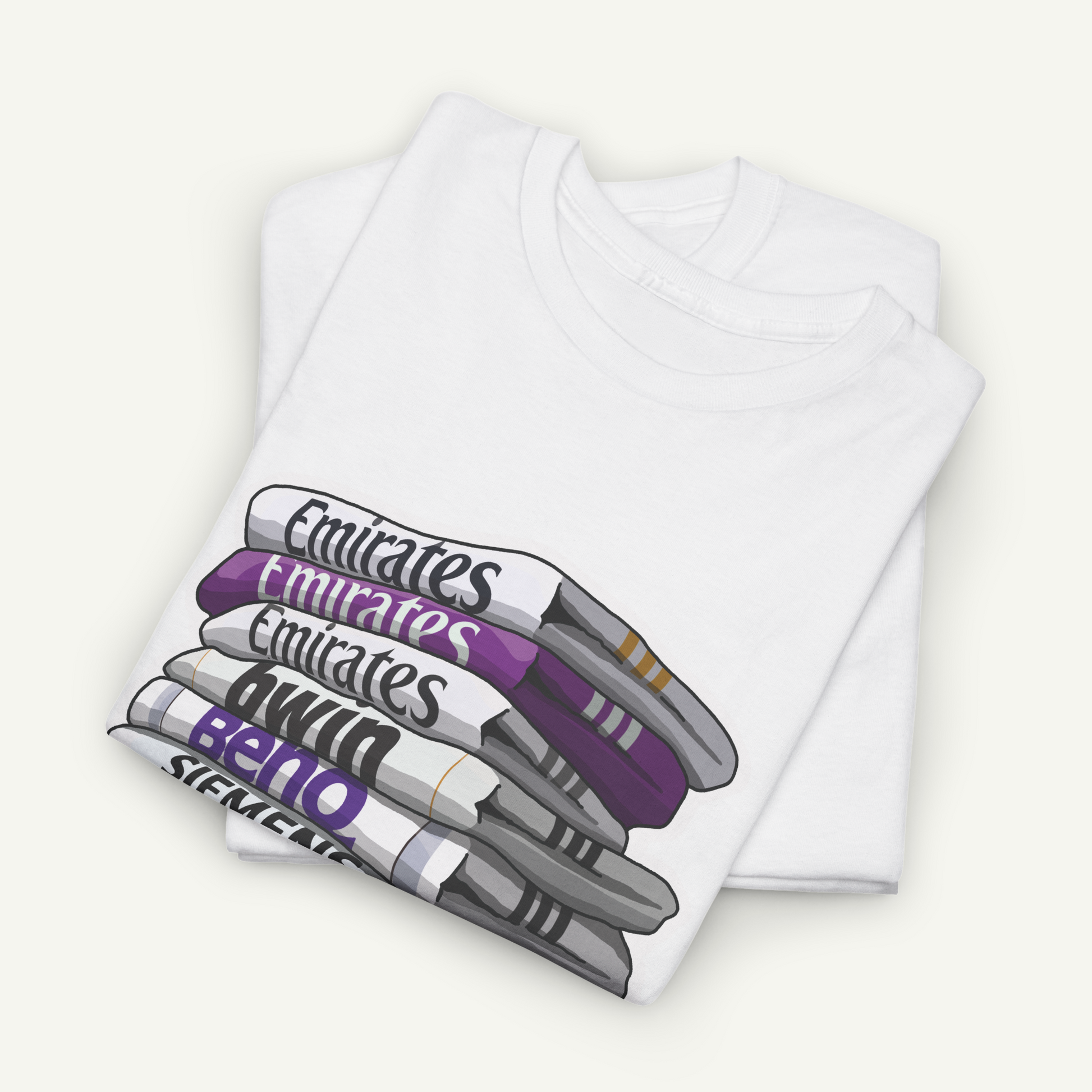 A white t-shirt with a graphic design depicting a stack of books or magazines with the text "Emirates" printed on them.