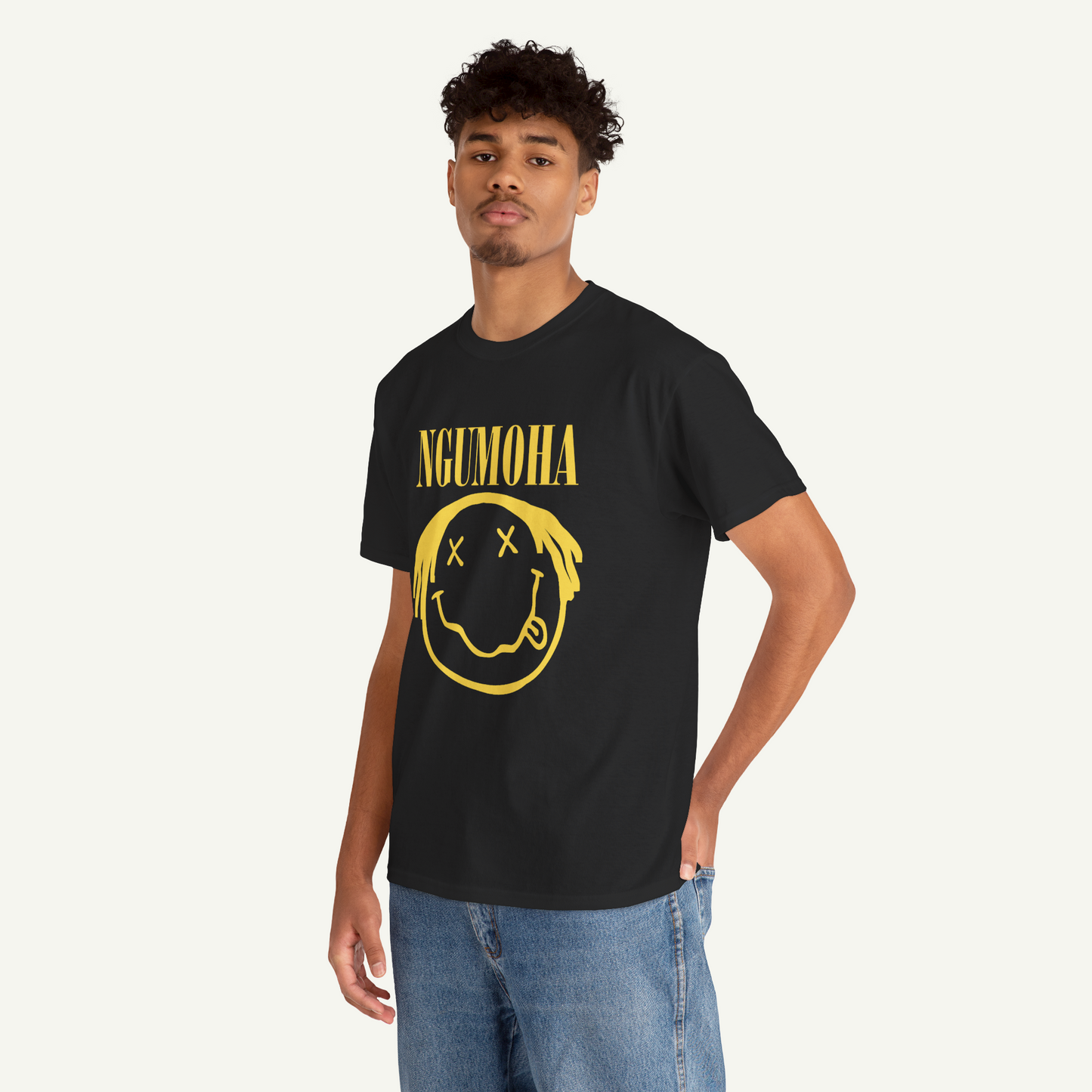 A young man wearing a black t-shirt with a yellow smiley face graphic and the text "NGUMOHA" printed on it.
