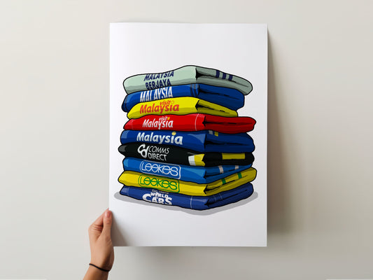 A hand is holding a poster with a stack of colorful shirts, each with a different country's name written on it.