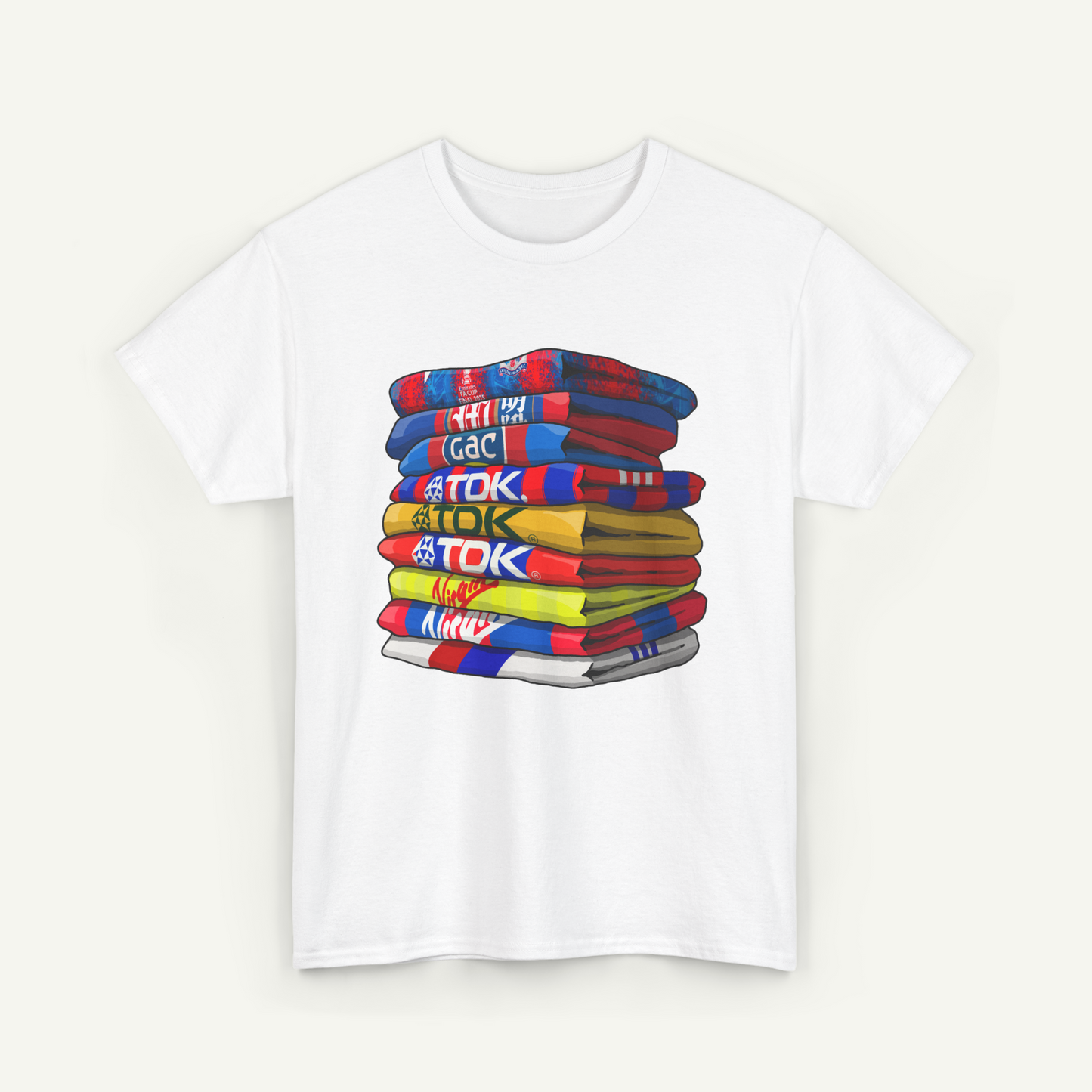 A white t-shirt with a colorful stack of towels or blankets, each with a different design or pattern.