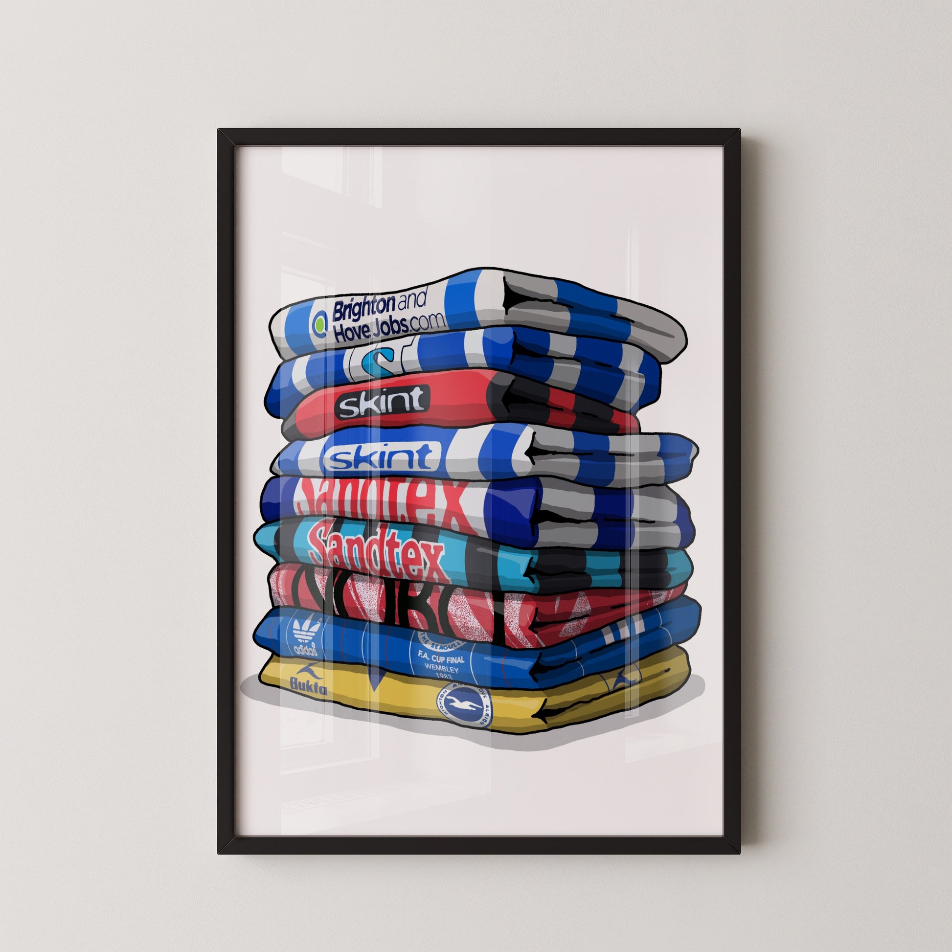 A framed illustration of a stack of colorful towels with various logos and text on them.