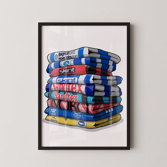 A framed illustration of a stack of colorful towels with various logos and text on them.
