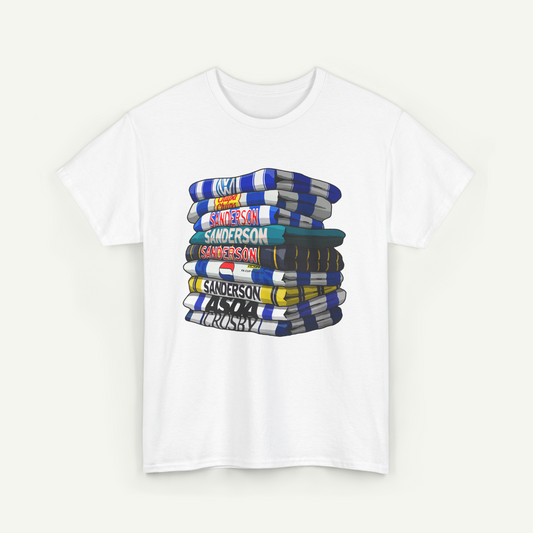 A white t-shirt with a graphic design depicting a stack of colorful books or magazines.