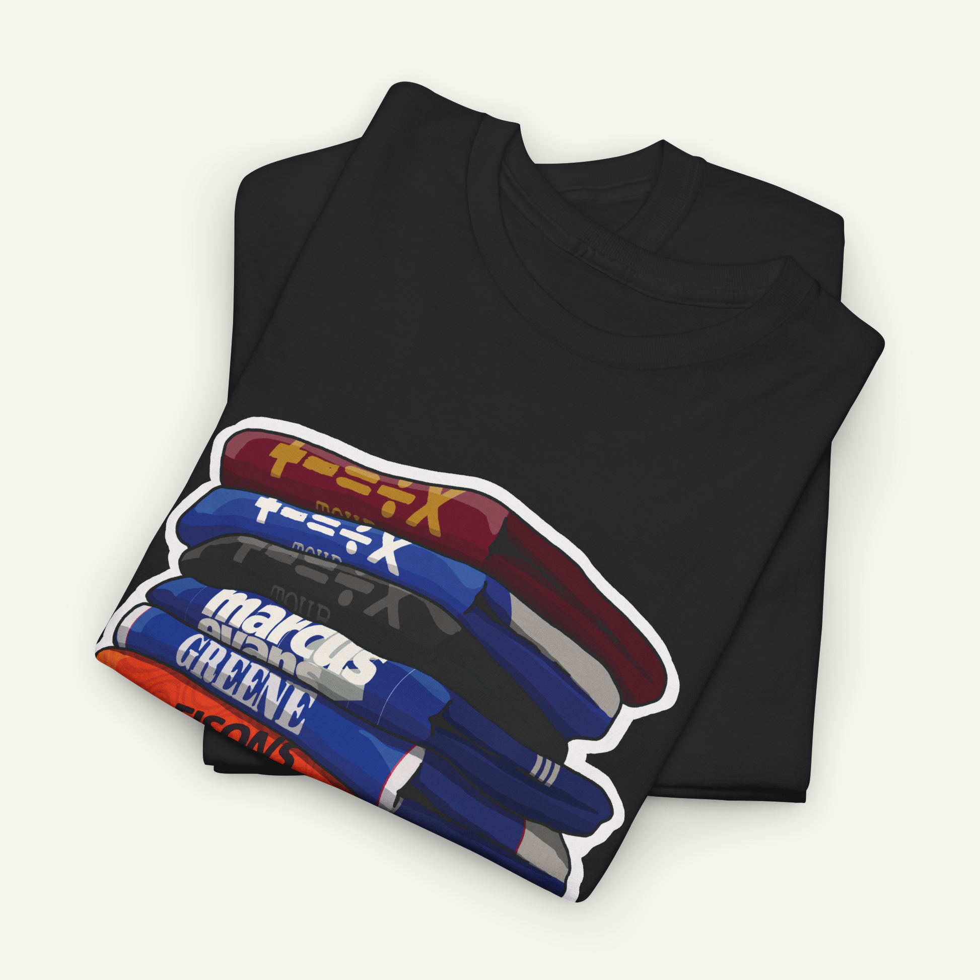 A black t-shirt with a graphic design depicting a stack of colorful books or magazines.
