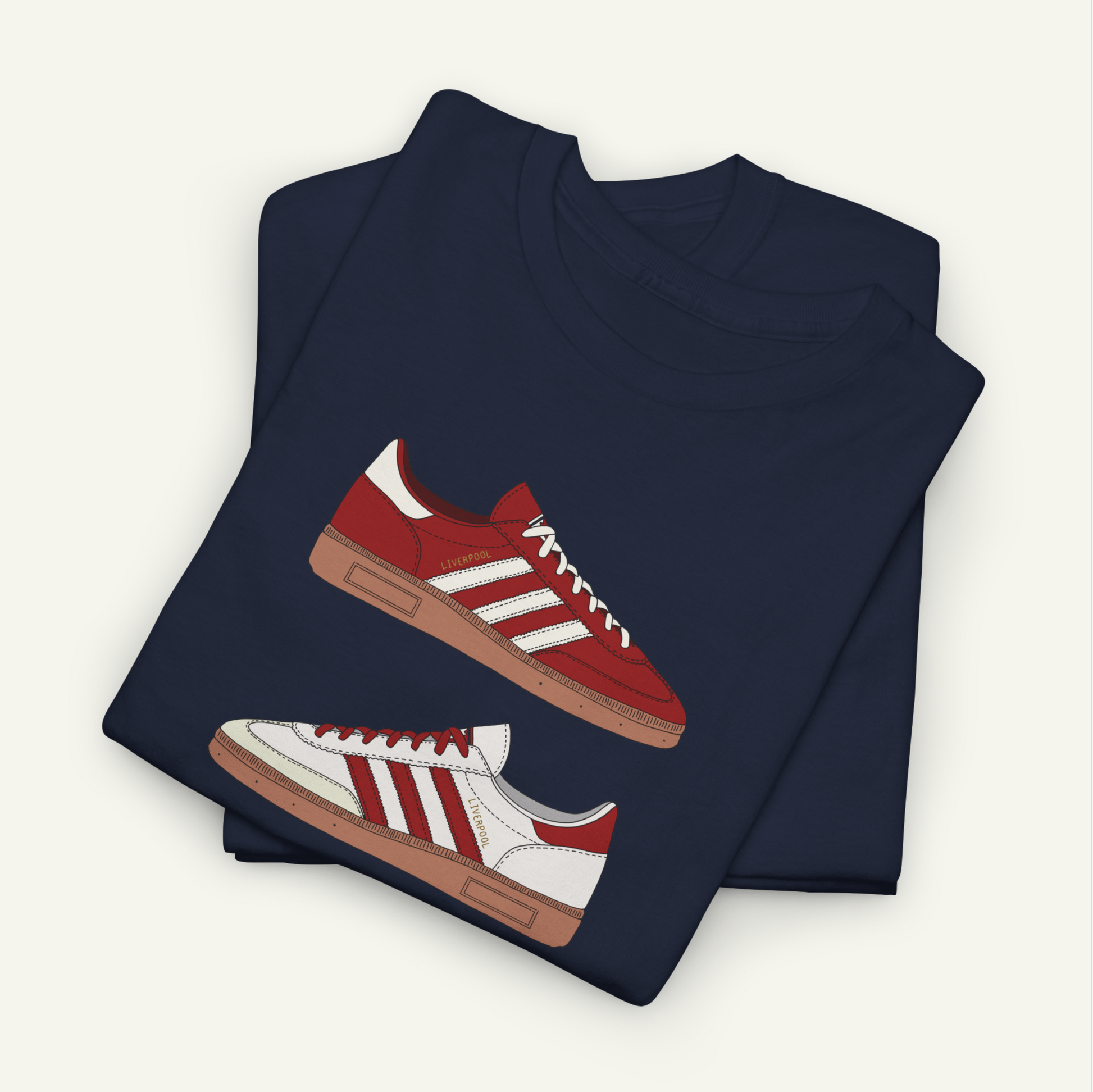 A navy blue t-shirt with a graphic design of red and white Adidas sneakers printed on it.