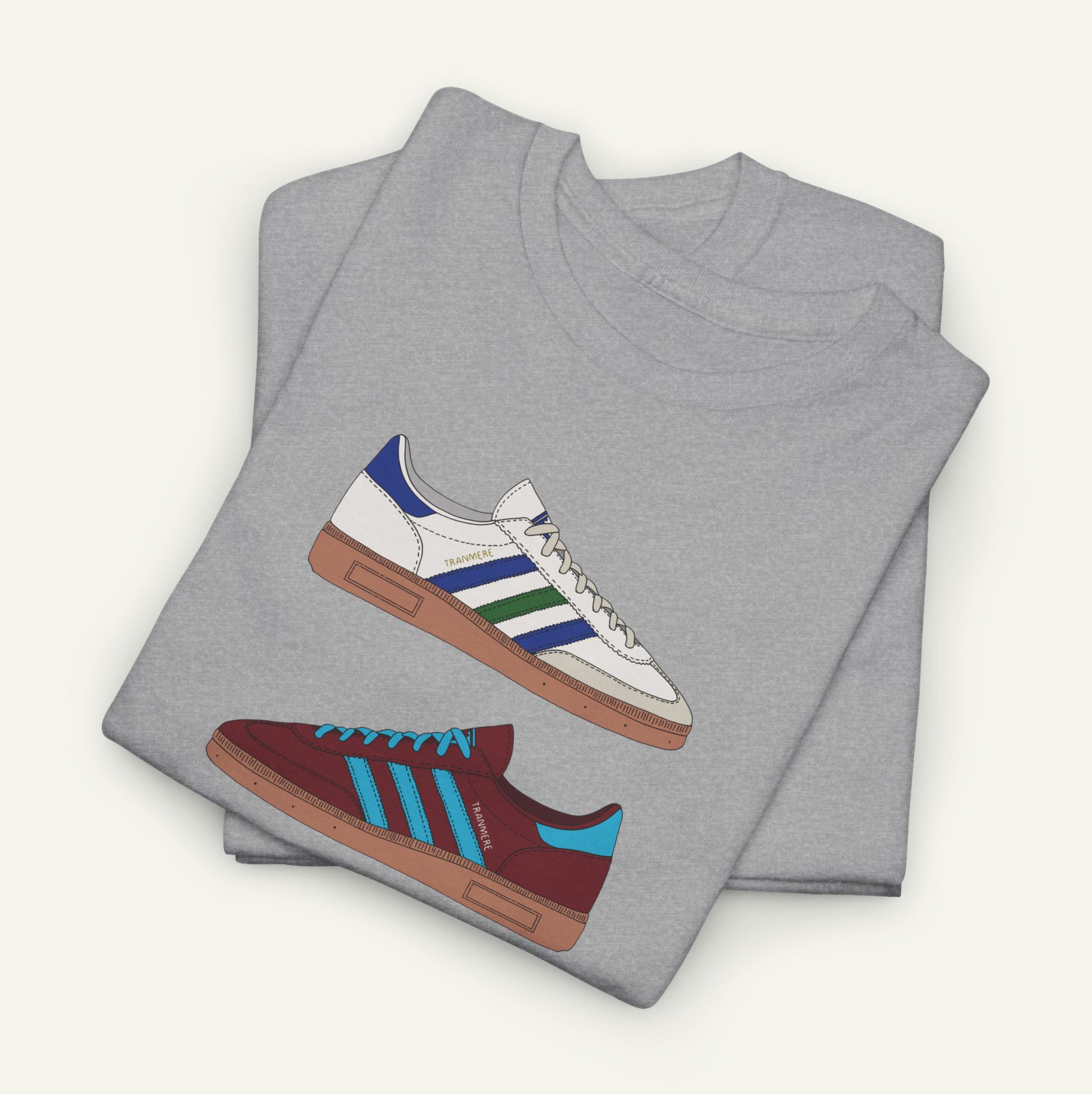 A gray t-shirt with a graphic design of two different colored Adidas sneakers.
