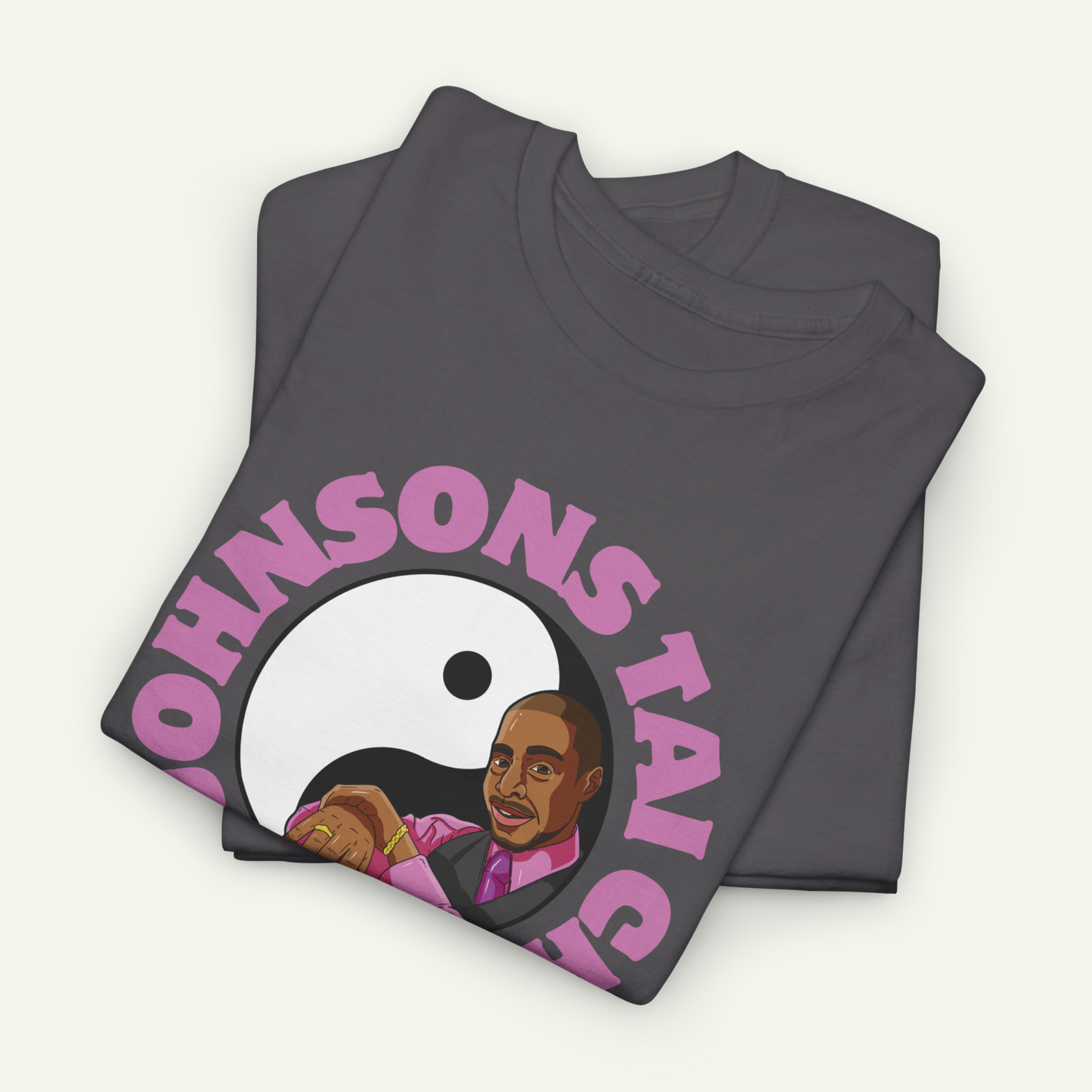 a gray t-shirt with a graphic design featuring a man's face and the text "OHNSON'S TAI" in pink.