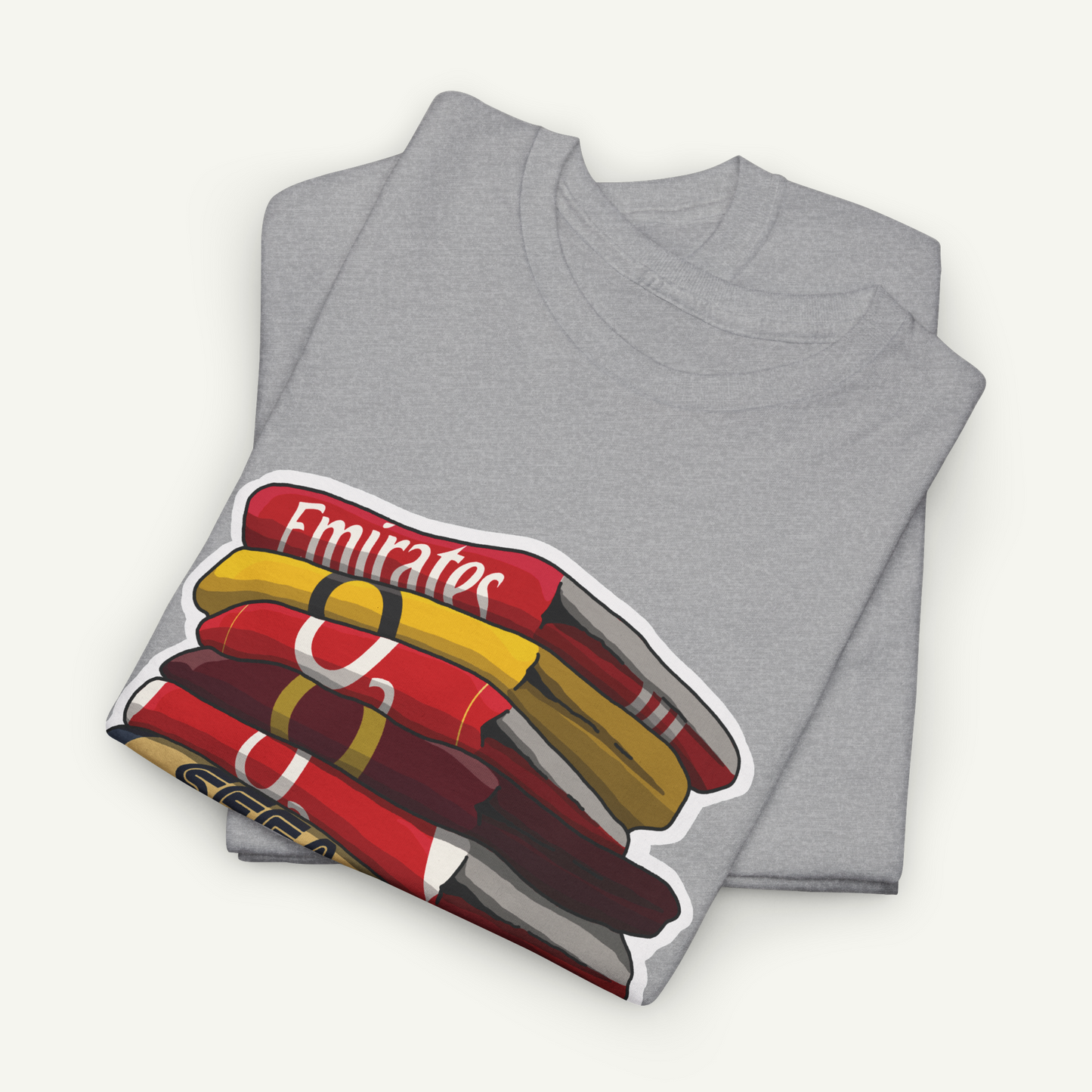 A gray t-shirt with a graphic design depicting a stack of colorful books or magazines.