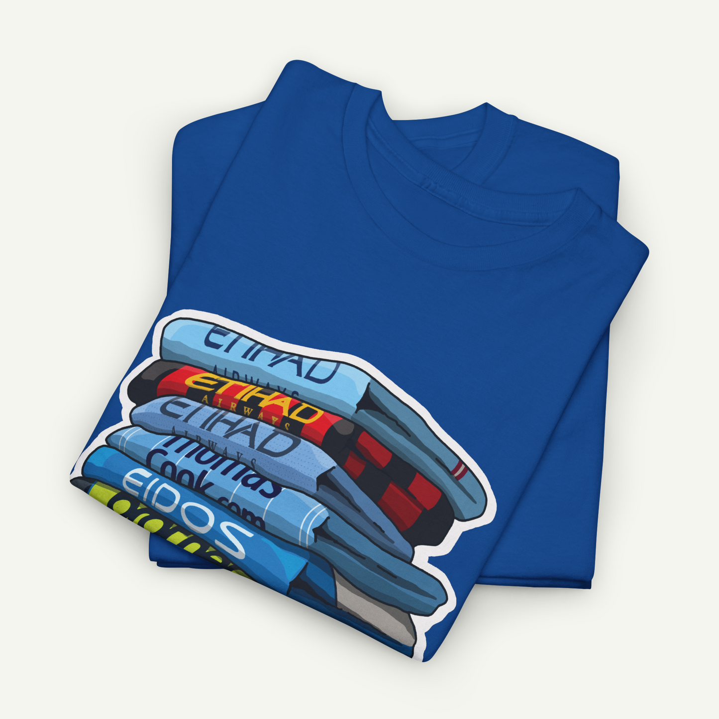 A blue t-shirt with a graphic design depicting a stack of books or magazines.