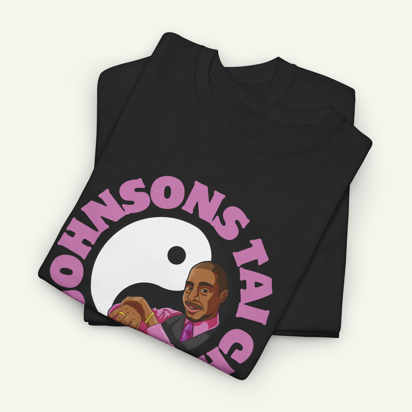 a black t-shirt with a graphic design depicting a man wearing a suit and tie, along with the text "OHNSON'S TAI" printed on it.