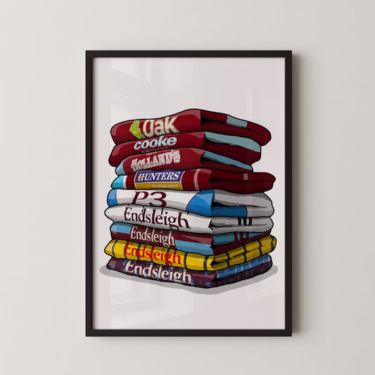A framed illustration of a stack of colorful towels with various text on them, including "Oak", "coat", "Holland's", "Hunters", "Endsleigh", and "Endsleigh".