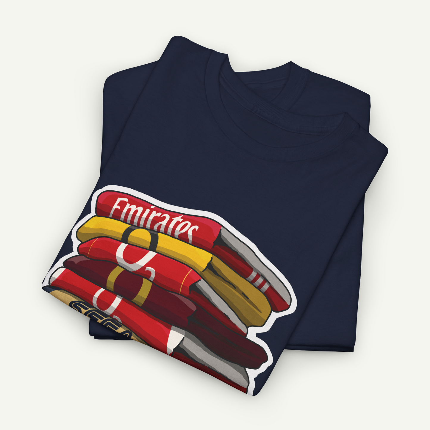 A navy blue t-shirt with a graphic design depicting a stack of colorful books or magazines.