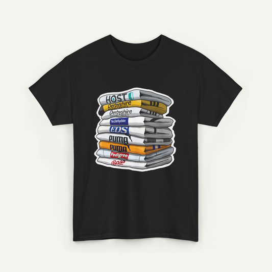 A black t-shirt with a graphic design depicting a stack of books or magazines with various colored covers, representing different types of media or content.