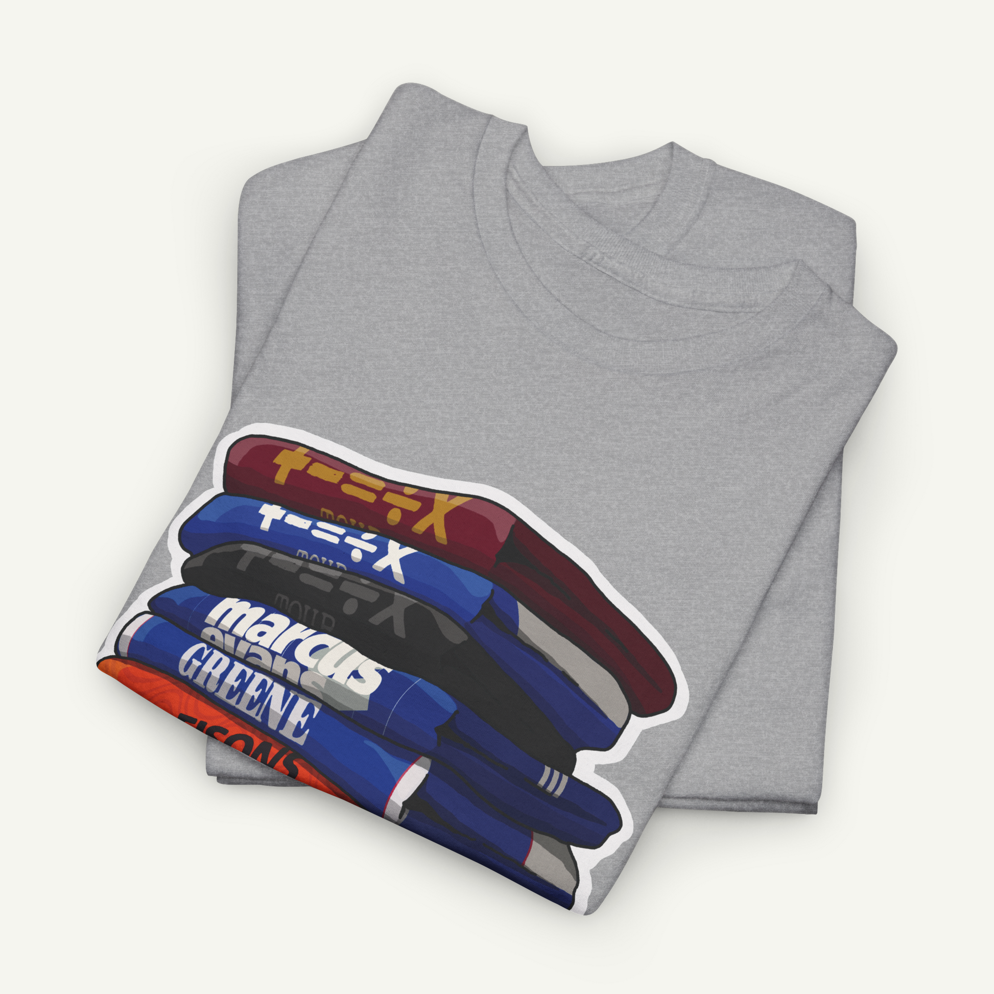 A gray t-shirt with a graphic design depicting a stack of books or magazines with various colored covers.