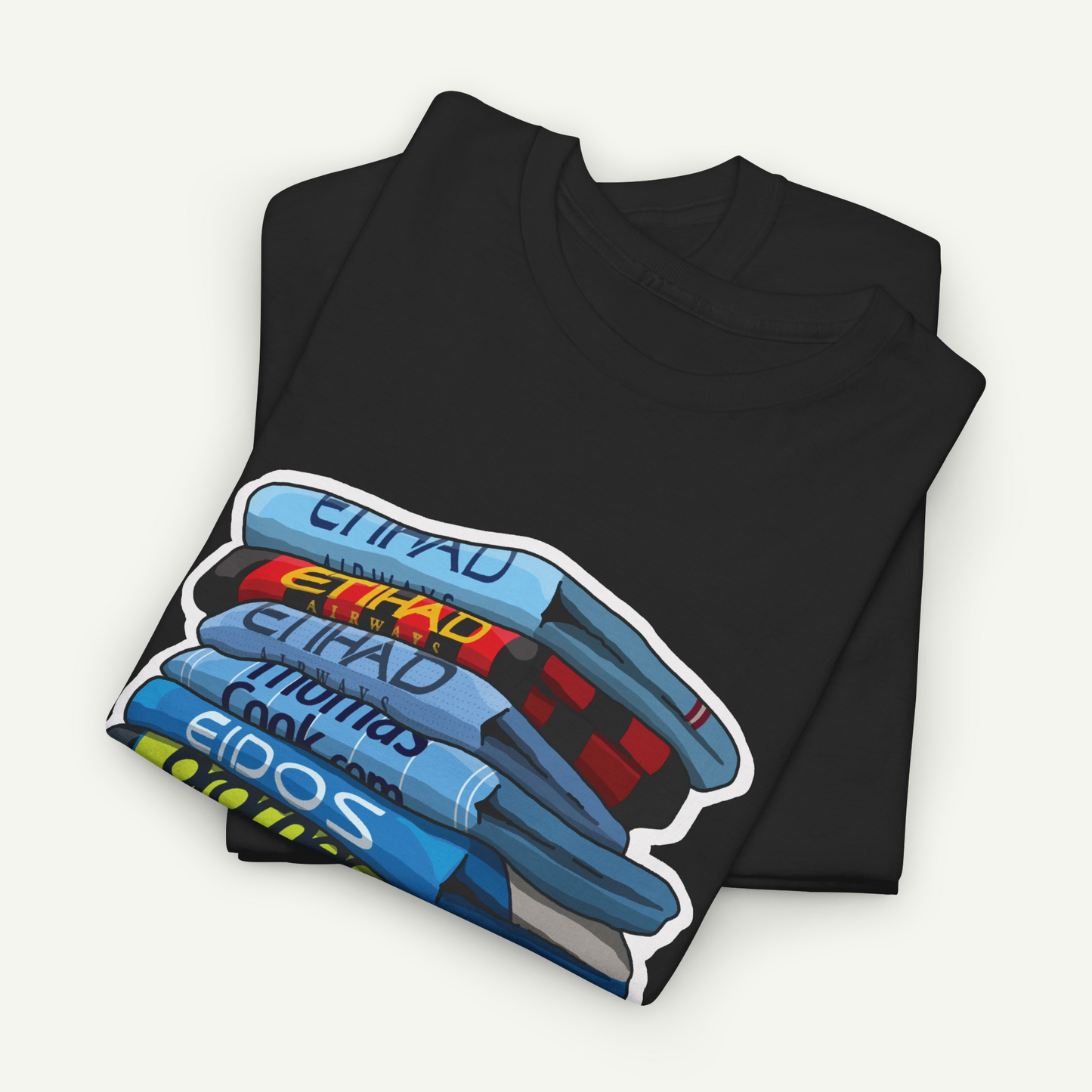 A black t-shirt with a colorful graphic design depicting a stack of books or magazines.