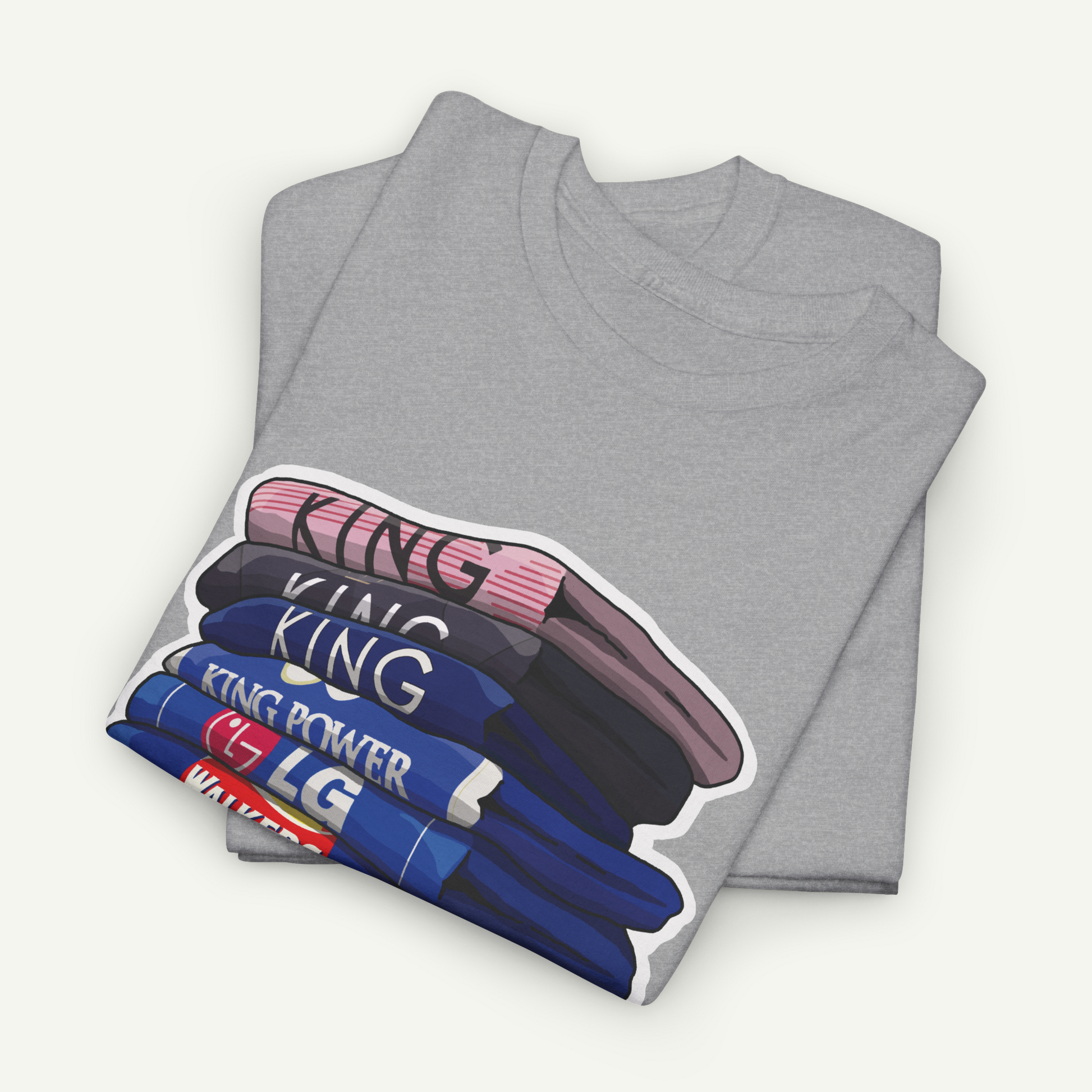 A gray t-shirt with a graphic design depicting a stack of books or magazines with the word "KING" printed on them.