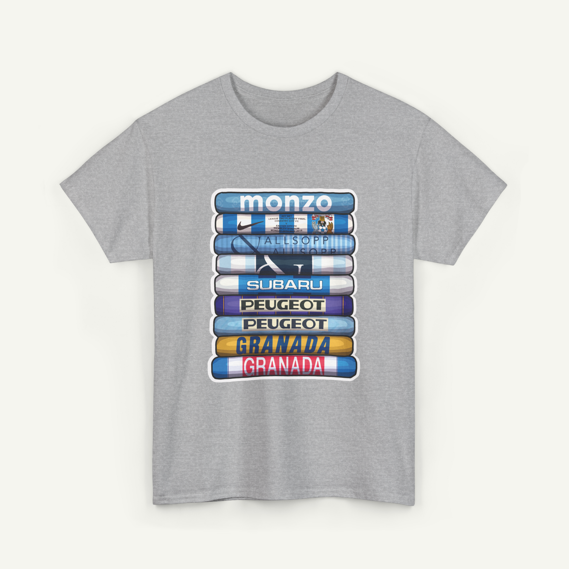 A gray t-shirt with a graphic design featuring a stack of colorful books or magazines with the titles of various car brands printed on them.