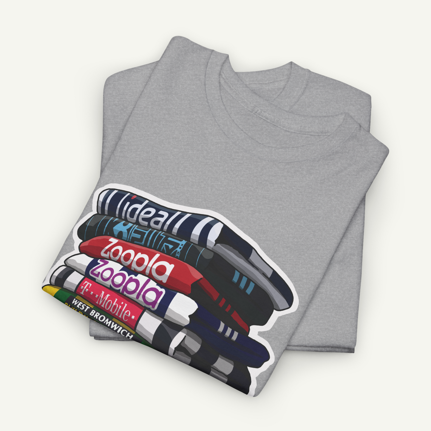A gray t-shirt with a graphic design depicting a stack of books with the text "ideal", "zooala", and "T-Mobile" printed on it.
