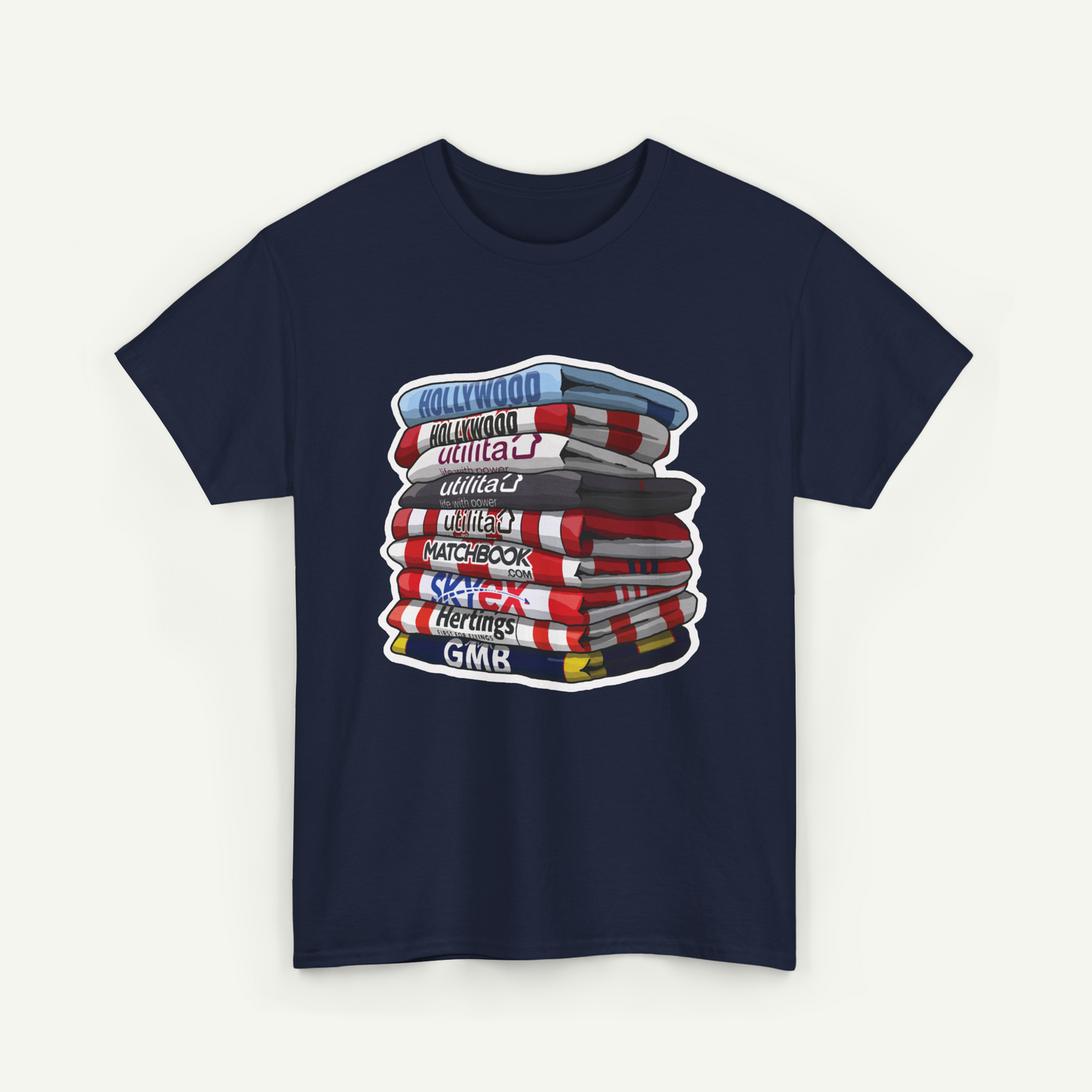 A navy blue t-shirt with a graphic design depicting a stack of colorful books or magazines with various titles such as "Hollywood", "Utilities", "Matchbook", "Heritage", and "GMK".