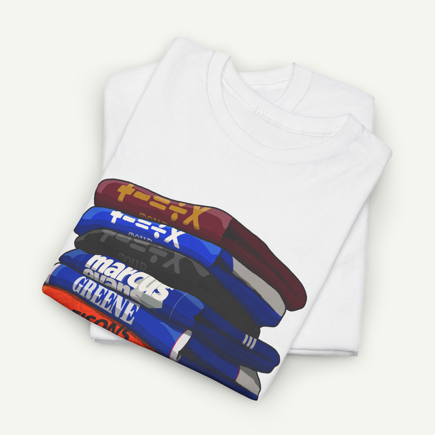A white t-shirt with a graphic design depicting a stack of colorful books or magazines.