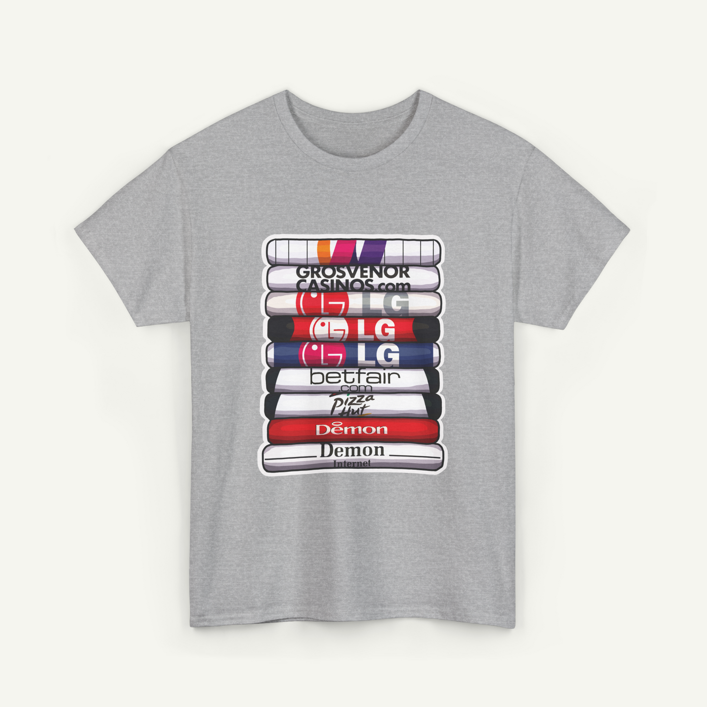 A gray t-shirt with a graphic design depicting a stack of colorful books or magazines, each with a different brand logo printed on it.