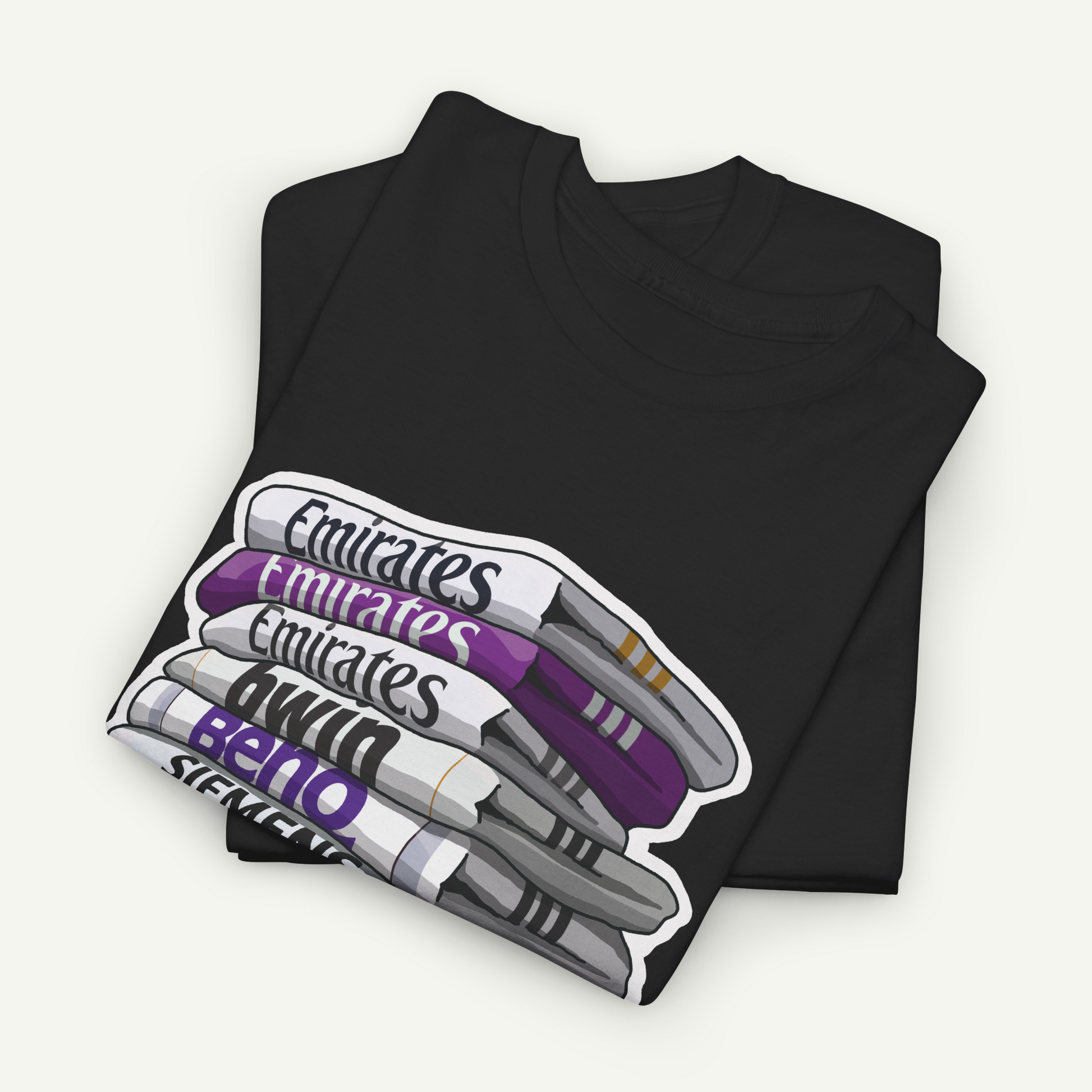 A black t-shirt with a graphic design depicting a stack of pens in various colors, including purple, white, and gray.