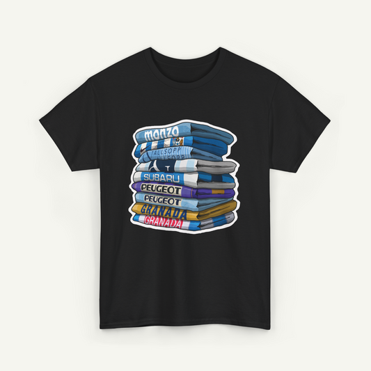 A black t-shirt with a graphic design depicting a stack of books or magazines with various titles written on them.