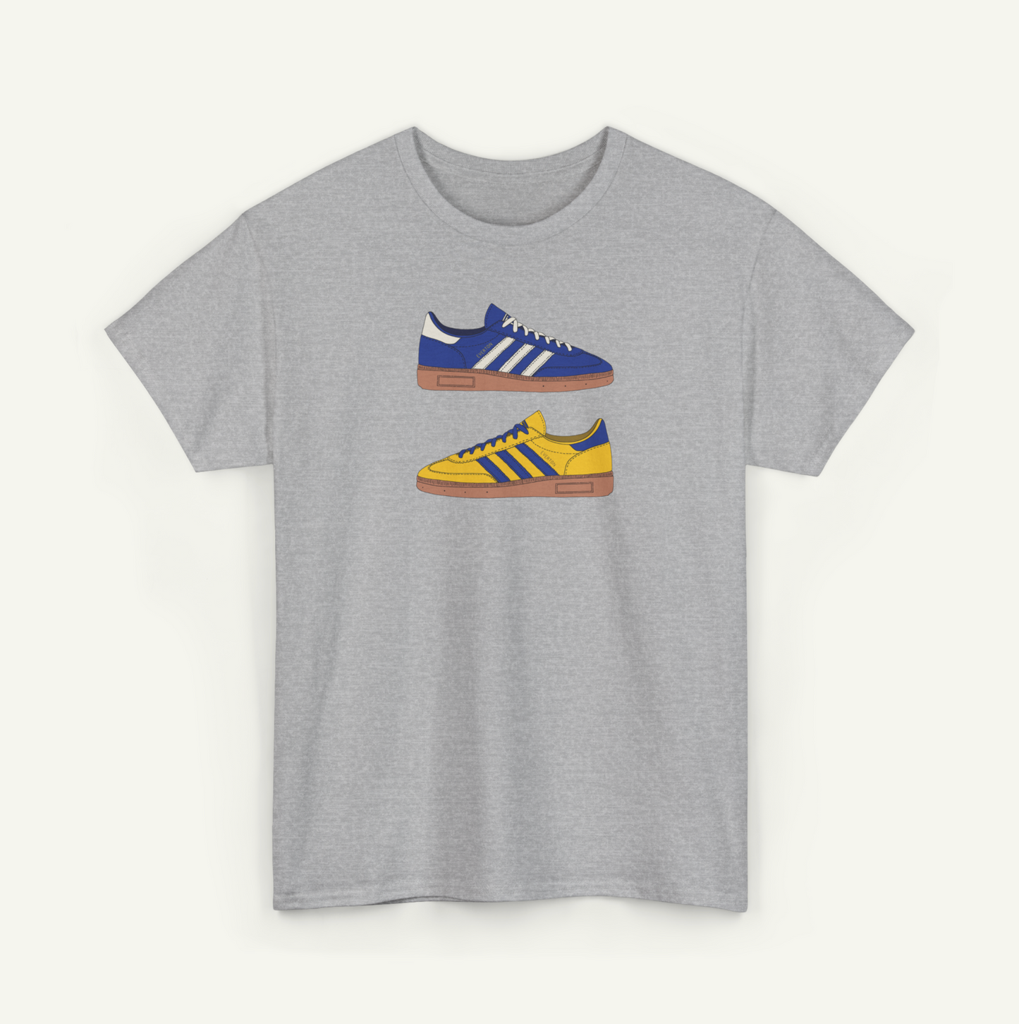 A gray t-shirt with a graphic design of two Adidas sneakers in blue and yellow colors.