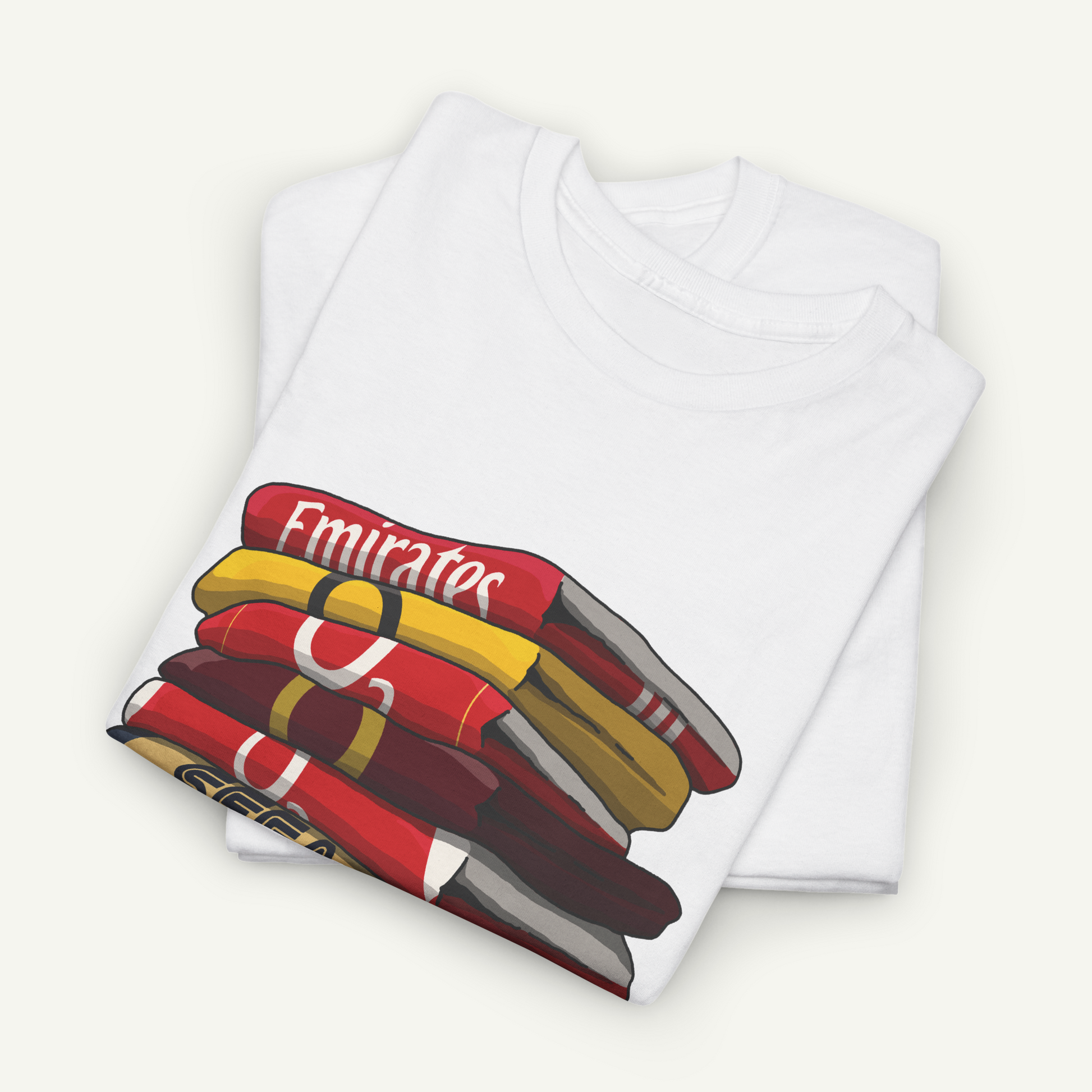 A white t-shirt with a graphic design depicting a stack of colorful books or magazines.