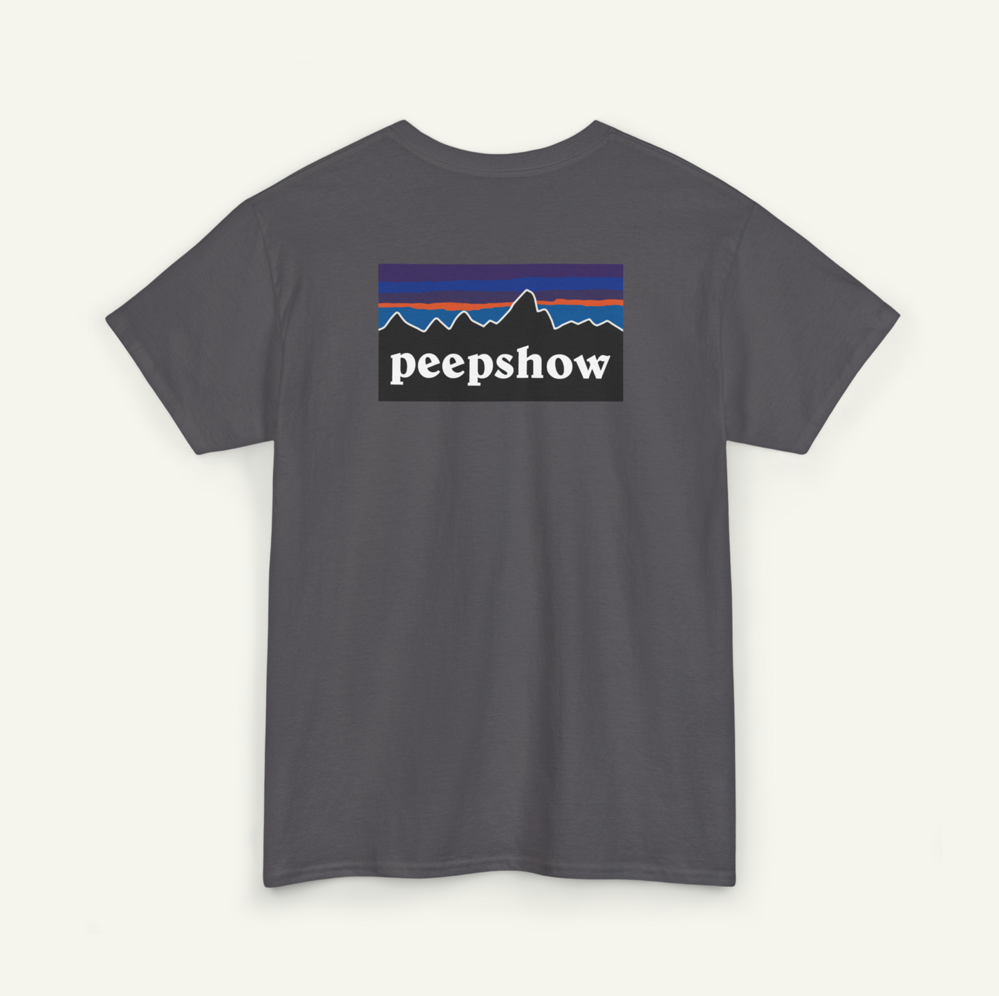 A gray t-shirt with a graphic design featuring a mountain range and the text "peepshow" printed on it.