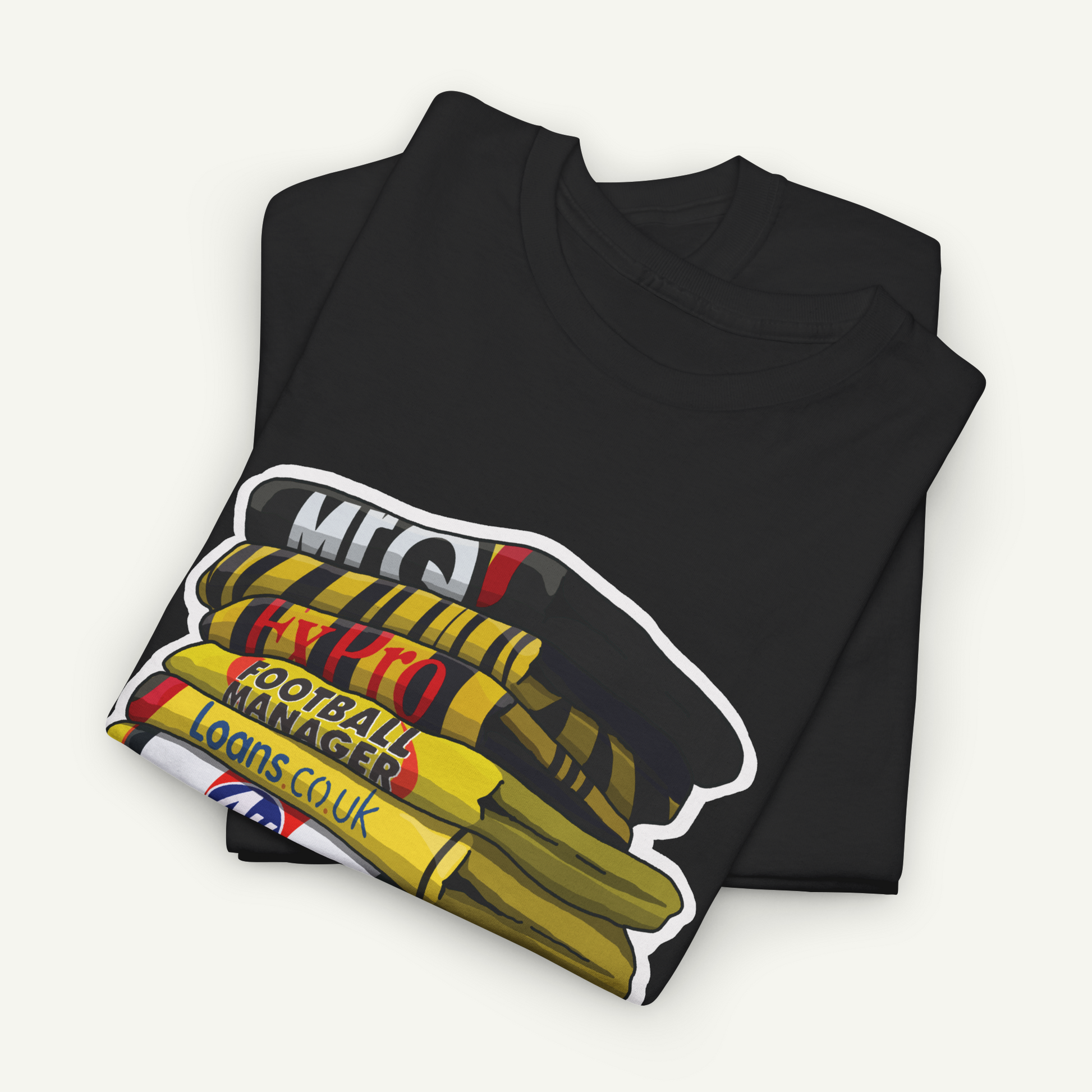 A black t-shirt with a graphic design depicting a stack of books or magazines with the text "M.E.C.O.L.O.N.C.UK" printed on it.