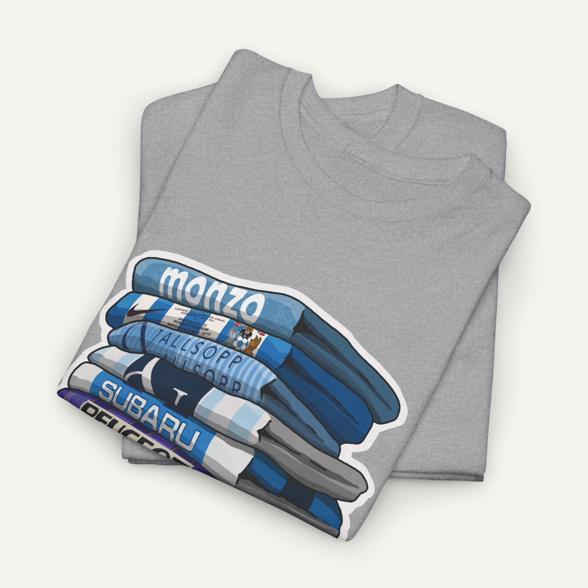 A gray t-shirt with a graphic design depicting a stack of blue and white striped shirts, along with the text "monzo" and "SUBIRU".