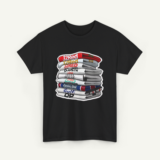A black t-shirt with a graphic design depicting a stack of books or magazines with various text labels on the spines.