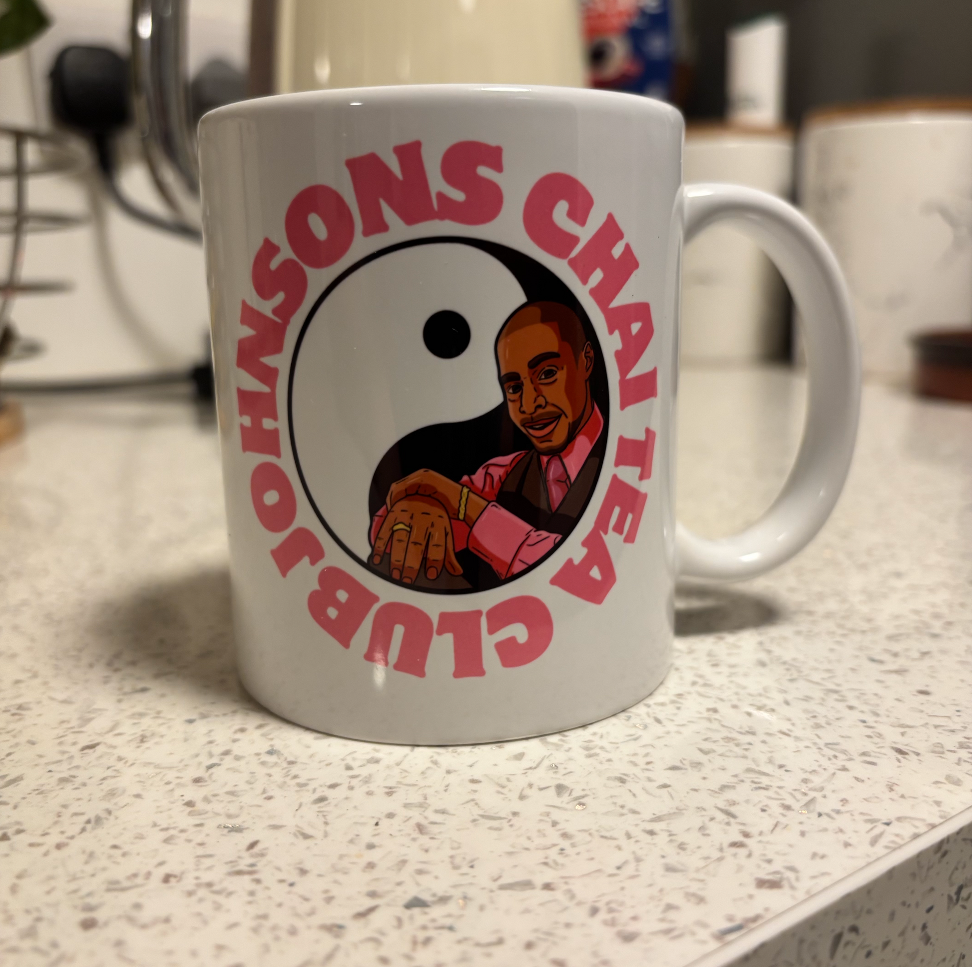 A white mug with a graphic design featuring a man in a pink shirt and a yin and yang symbol.