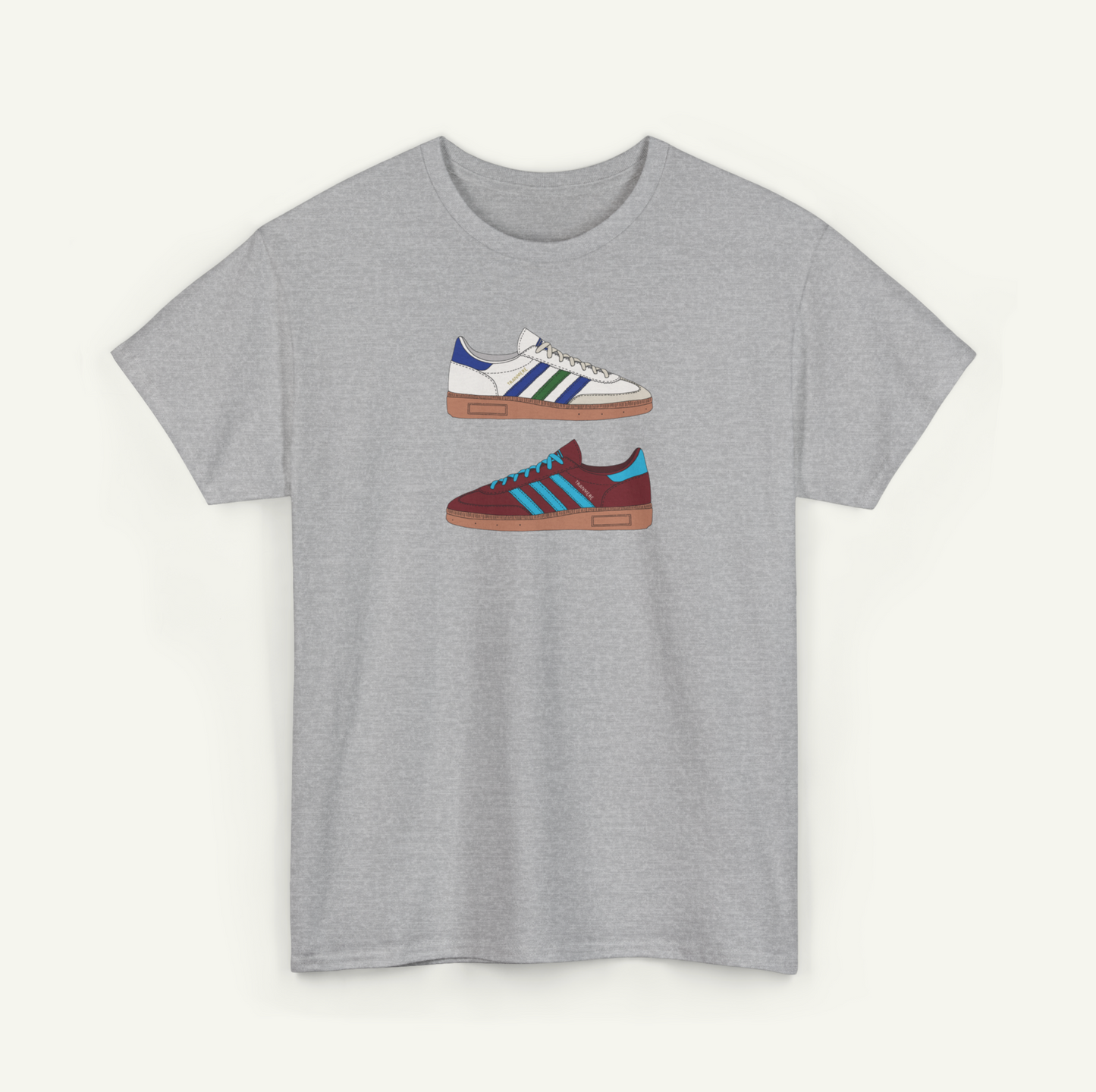 A gray t-shirt with a graphic design of two different colored Adidas sneakers.