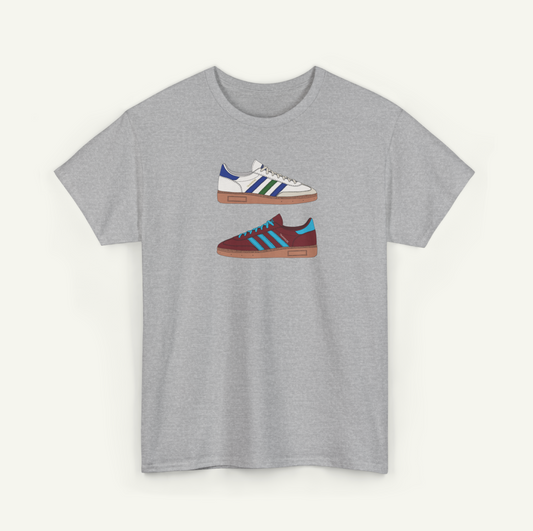 A gray t-shirt with a graphic design of two different colored Adidas sneakers.