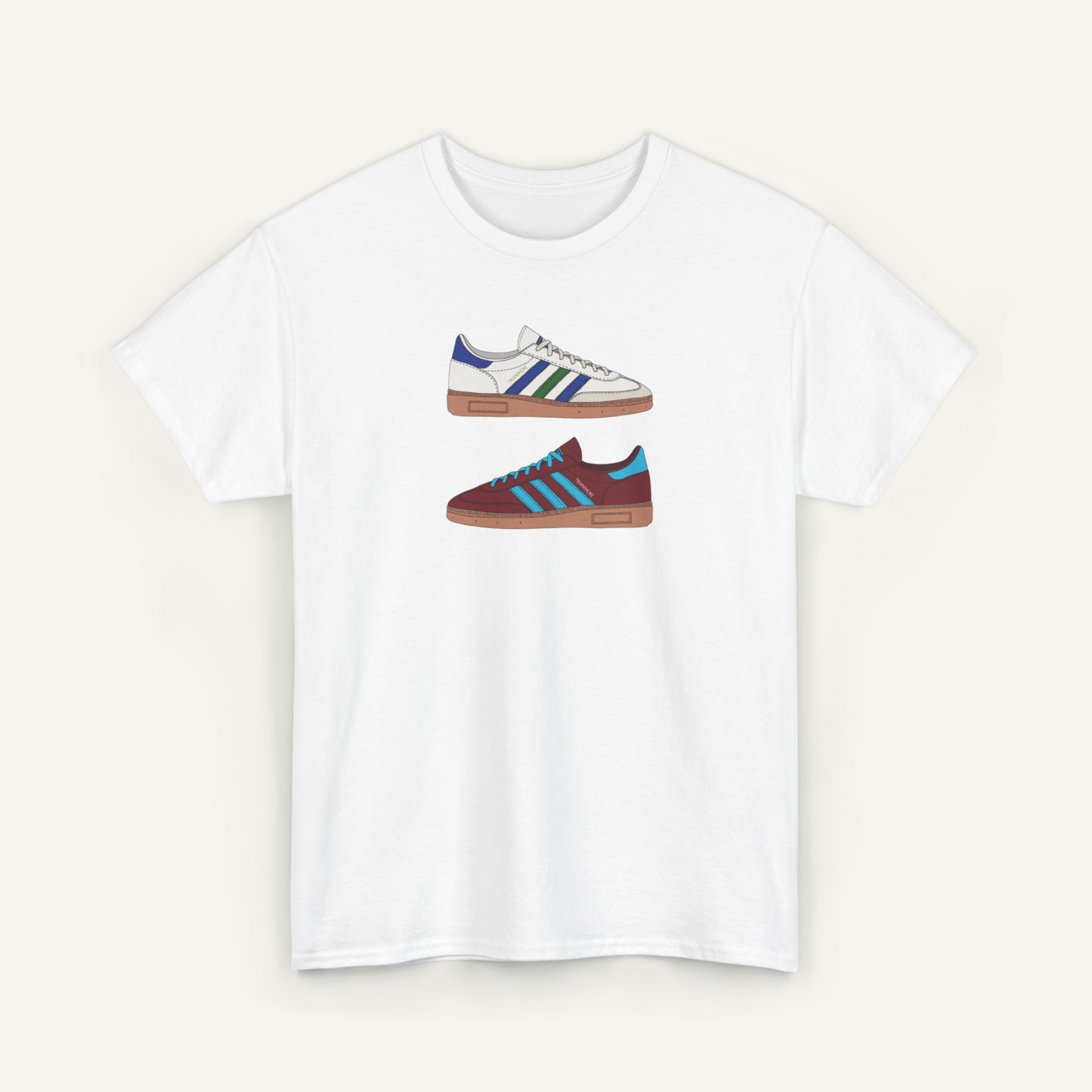 A white t-shirt with a graphic design of two different colored Adidas sneakers.