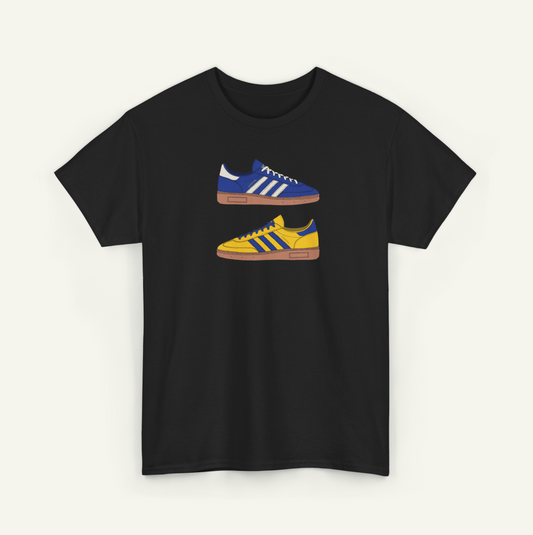 A black t-shirt with a graphic design of two Adidas sneakers in blue and yellow colors.