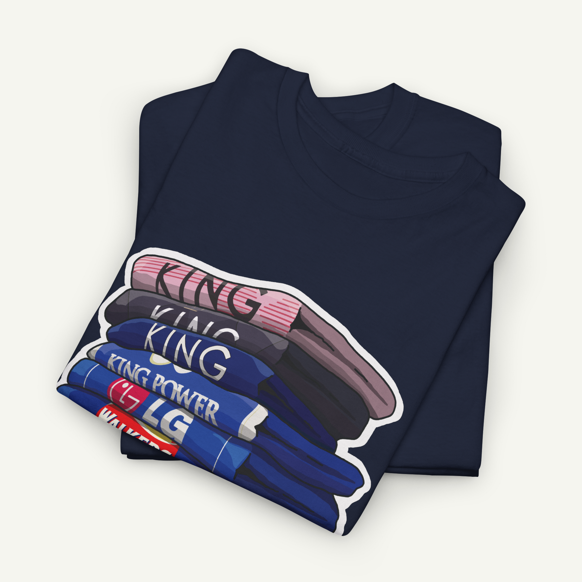 A dark blue t-shirt with a graphic design depicting a stack of shirts with the word "KING" printed on them.