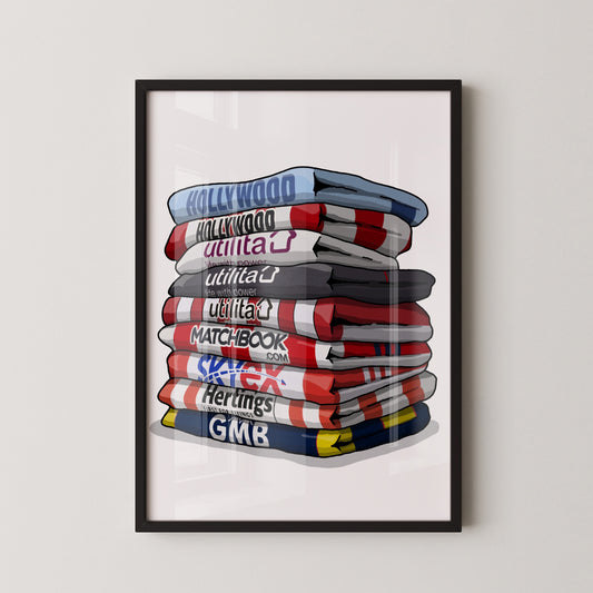 A framed illustration of a stack of colorful towels with various text printed on them, including "Hollywood", "Utilita", "Matchbook", "Herdings", and "GMB".