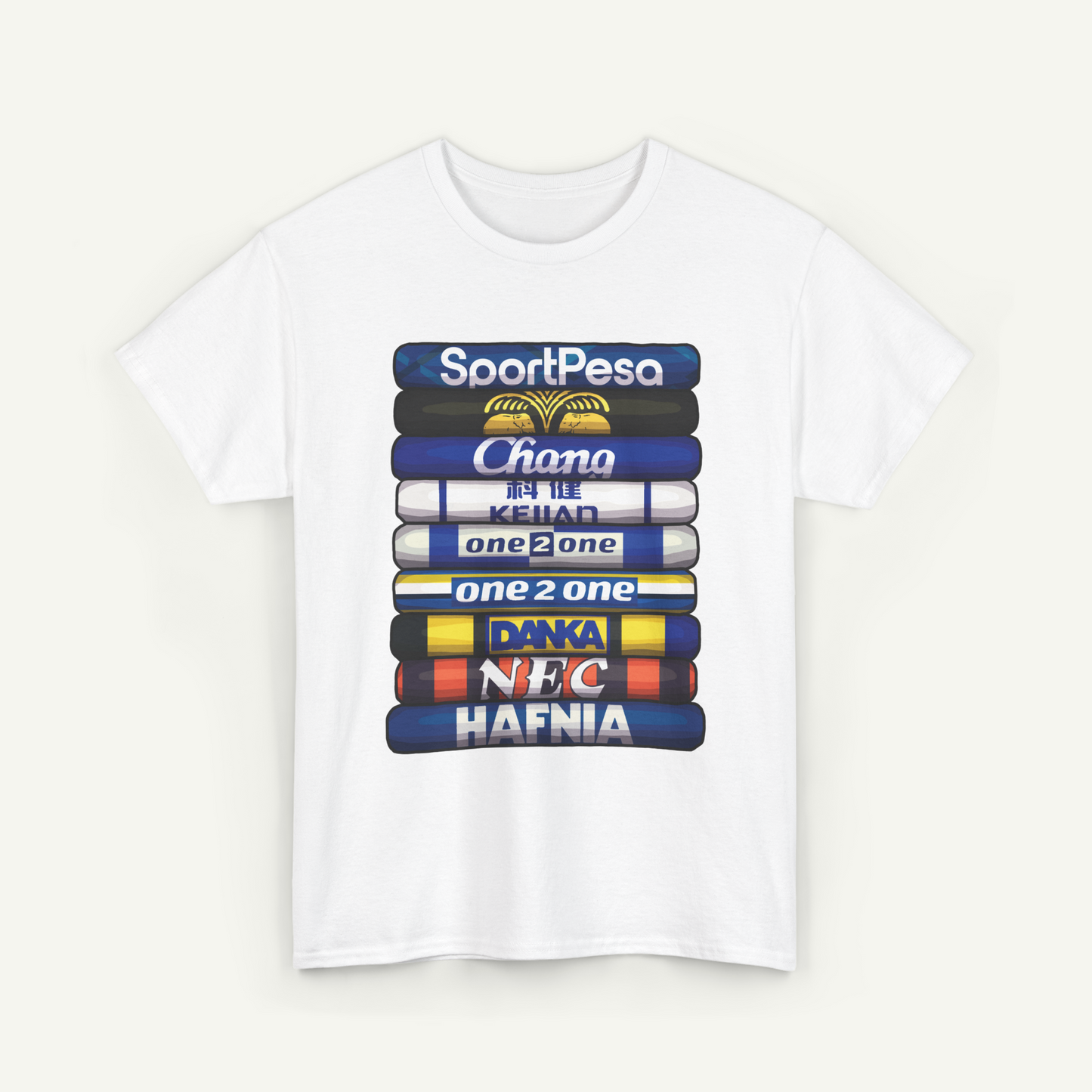 A white t-shirt with a graphic design featuring a stack of colorful books or magazines with various text and logos printed on them.