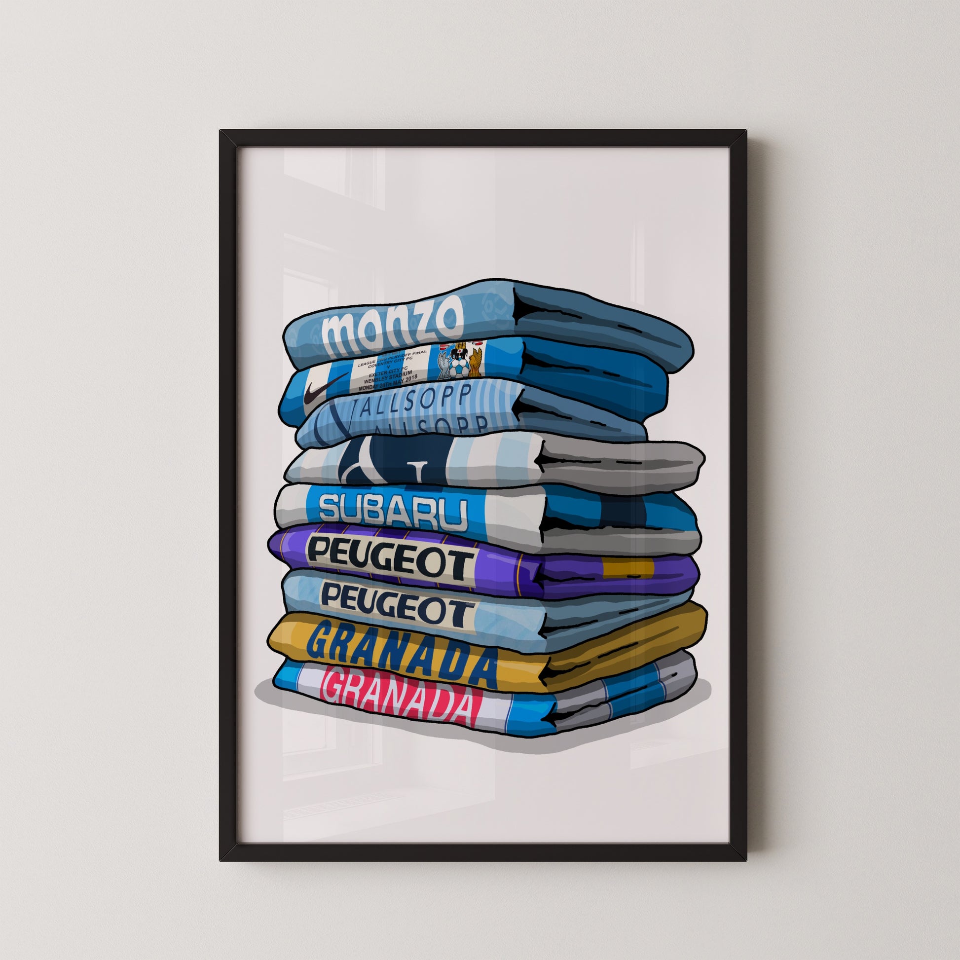 A framed illustration of a stack of folded towels with various text printed on them, including "MONZO", "ALLISOPPIO", "SUBARU", "PEUGEOT", "SUBARU", "PEUGEOT", "GRANDA", and "GRABANA".