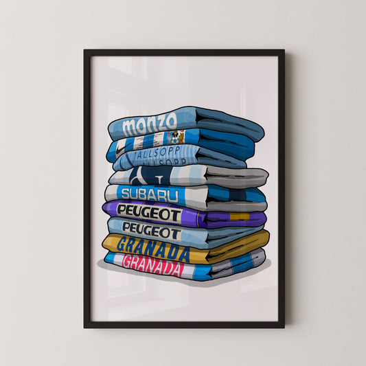 A framed illustration of a stack of folded towels with various text printed on them, including "MONZO", "ALLISOPPIO", "SUBARU", "PEUGEOT", "SUBARU", "PEUGEOT", "GRANDA", and "GRABANA".
