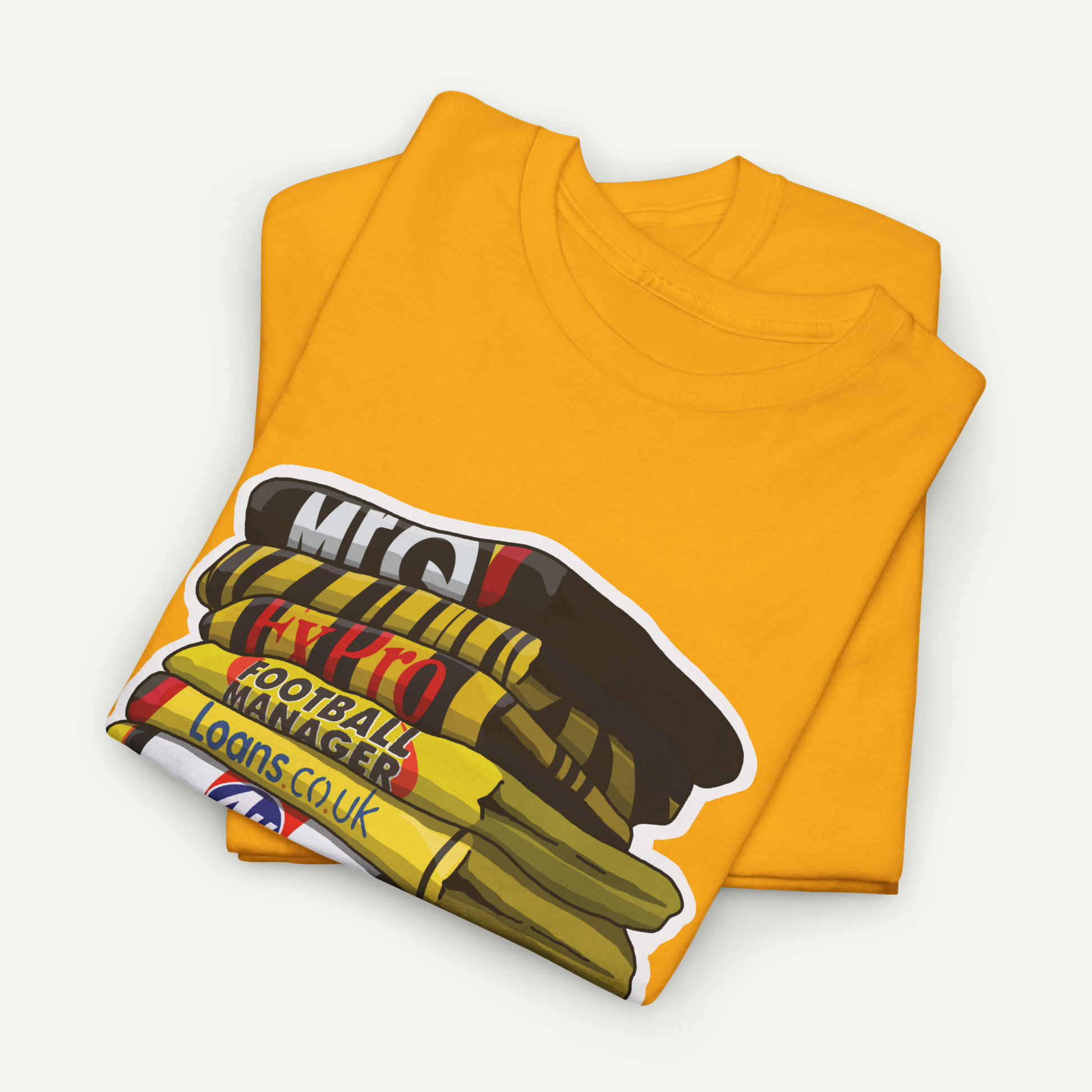 A yellow t-shirt with a graphic design depicting a stack of books or magazines, along with text that reads "MEC", "FOOTBALL MANAGER", and "LOANS COU".