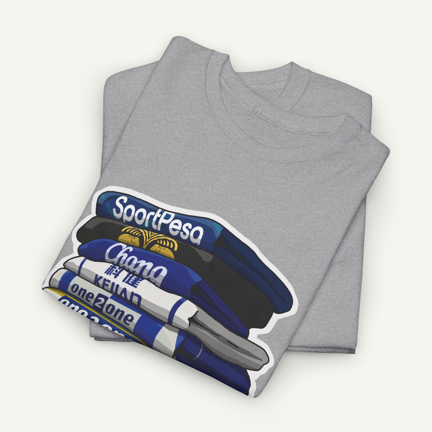 A gray t-shirt with a graphic design depicting a stack of books or magazines with the text "SportPesa" and "Chana" printed on them.
